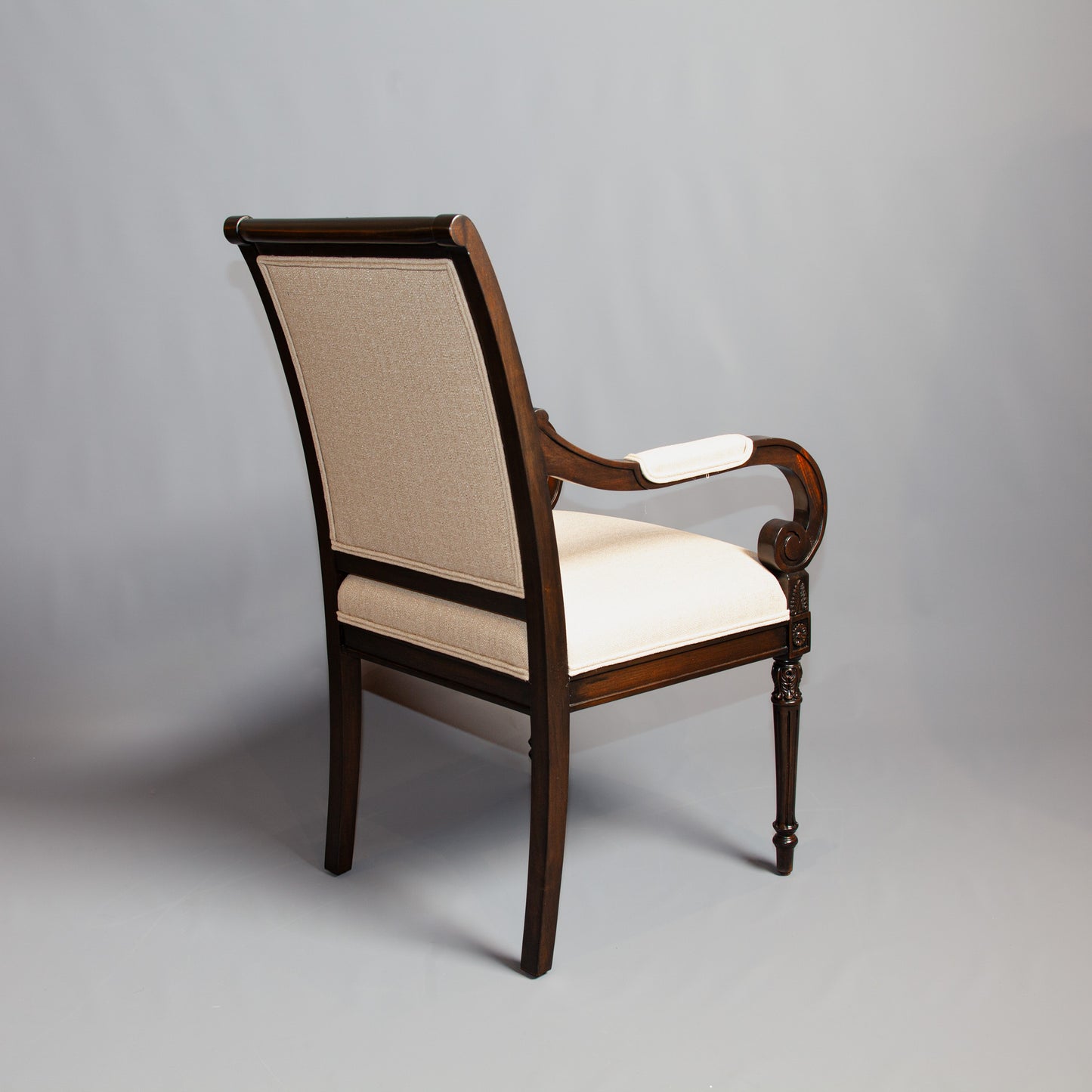 Luxurious Empire-style armchair featuring rich wood finish and patterned upholstery.