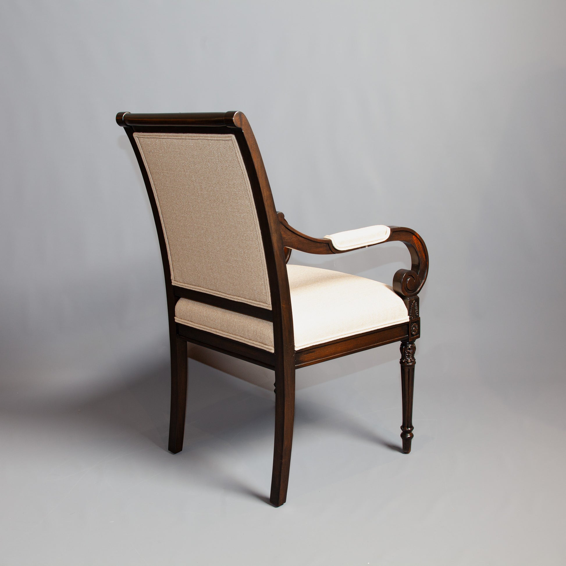 Luxurious Empire-style armchair featuring rich wood finish and patterned upholstery.