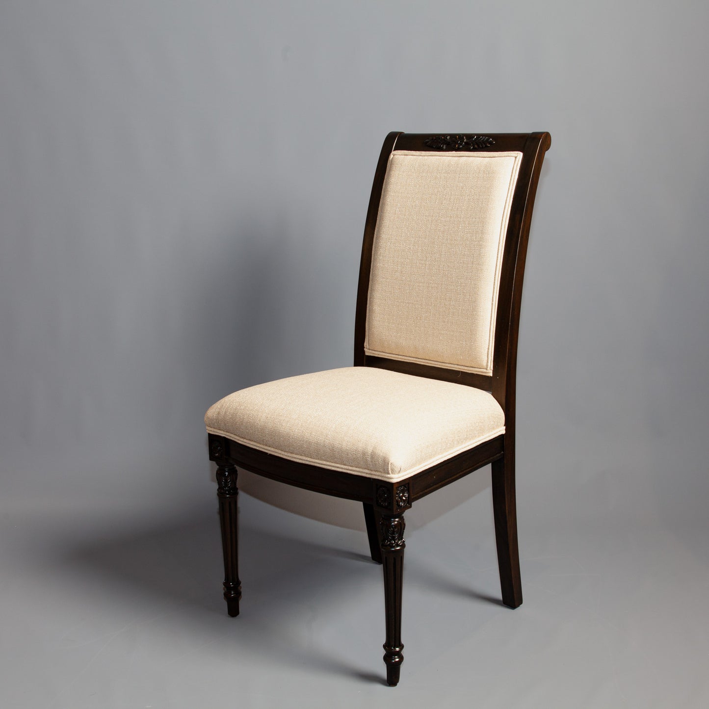 Front view of Empire-style side chair showcasing detailed carvings and striped fabric.