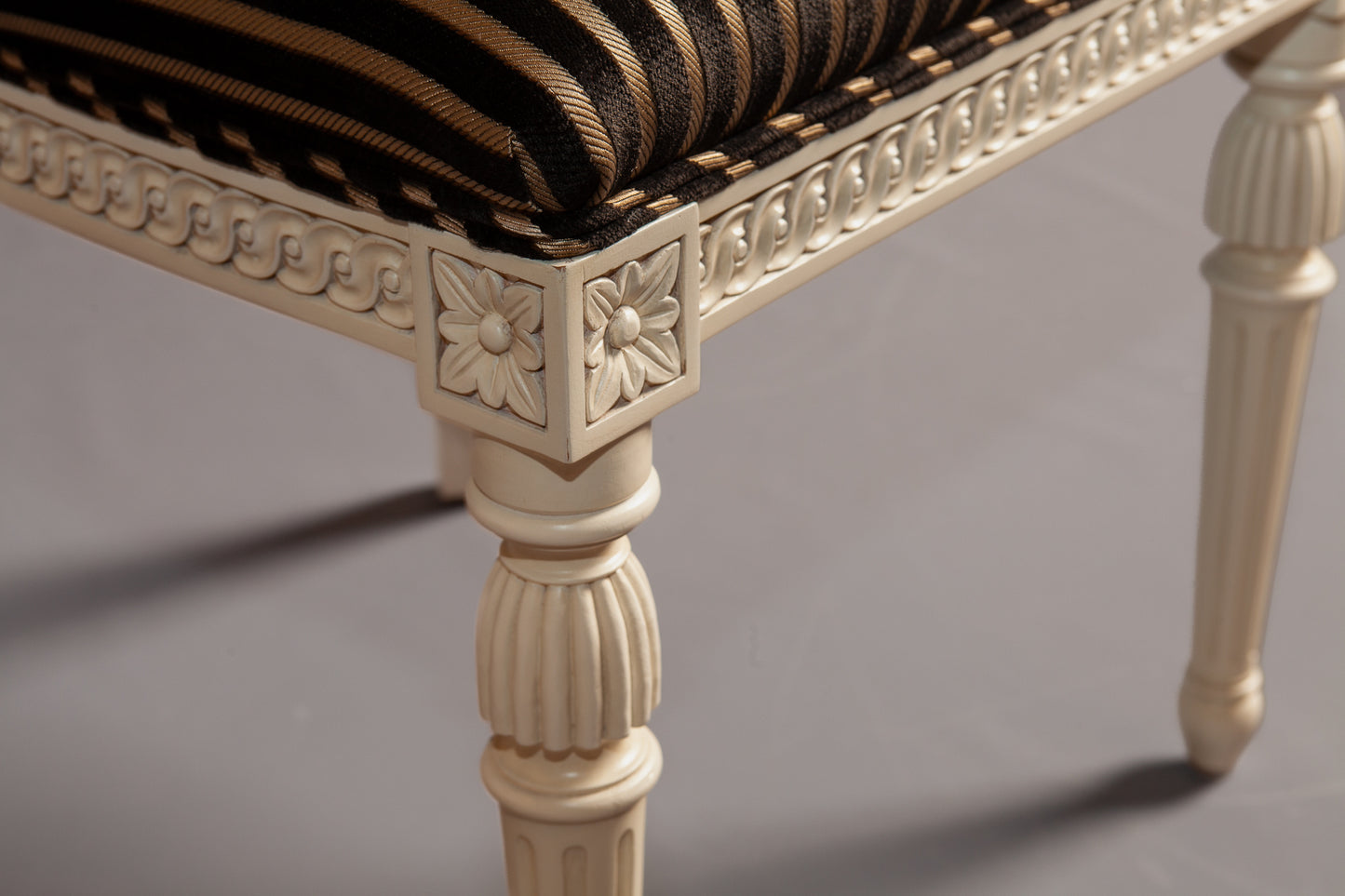 Detailed view of the chair's carved backrest and fabric pattern.
