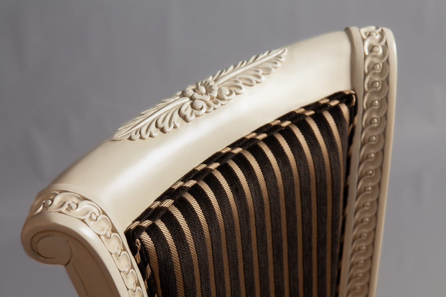 Close-up of the chair's armrest showcasing intricate woodwork.