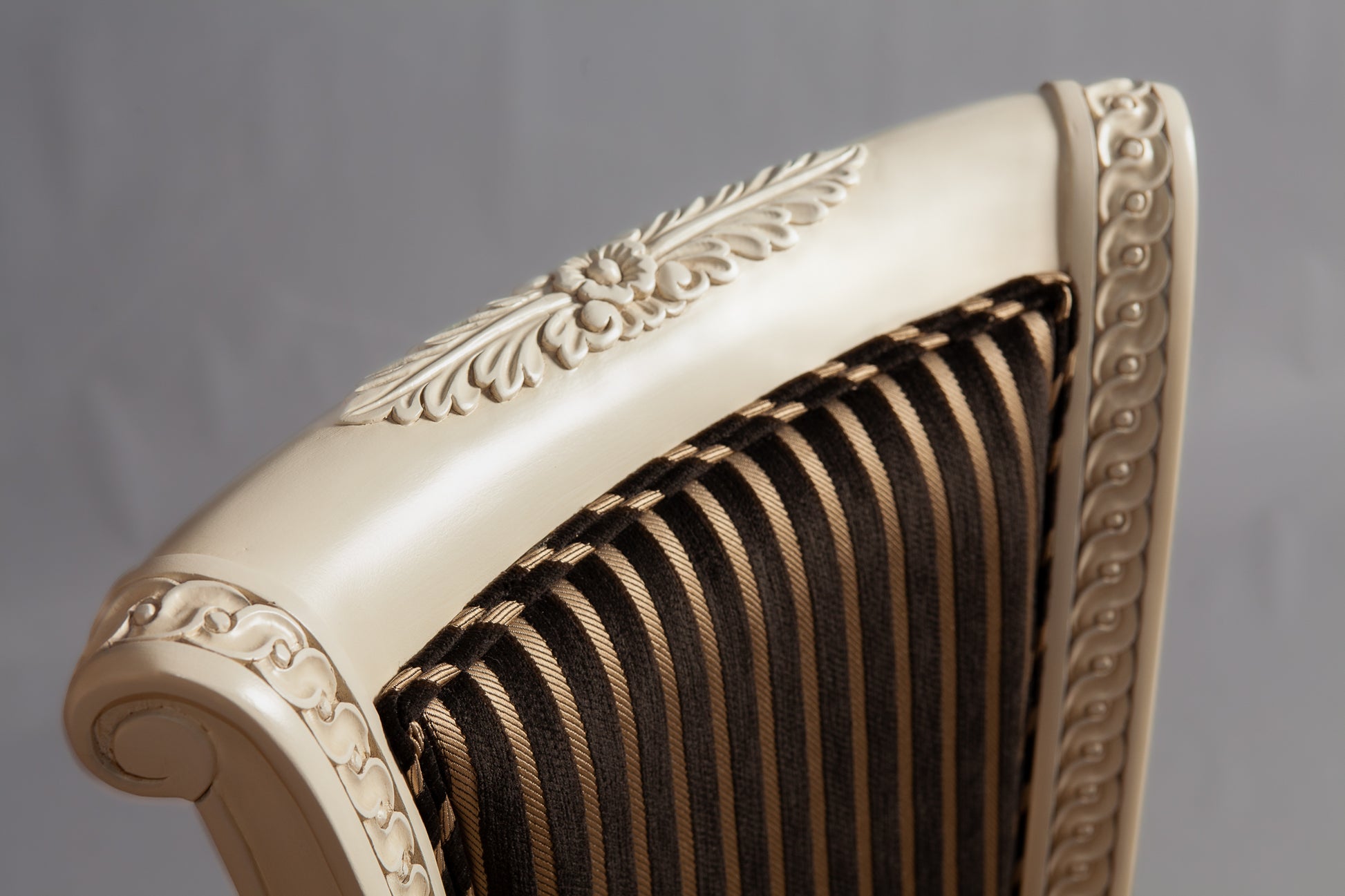 Close-up of the chair's armrest showcasing intricate woodwork.