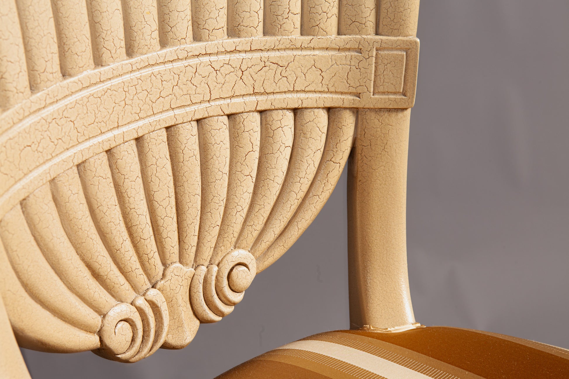Close-up of chair's backrest showcasing ornate woodwork and craftsmanship.