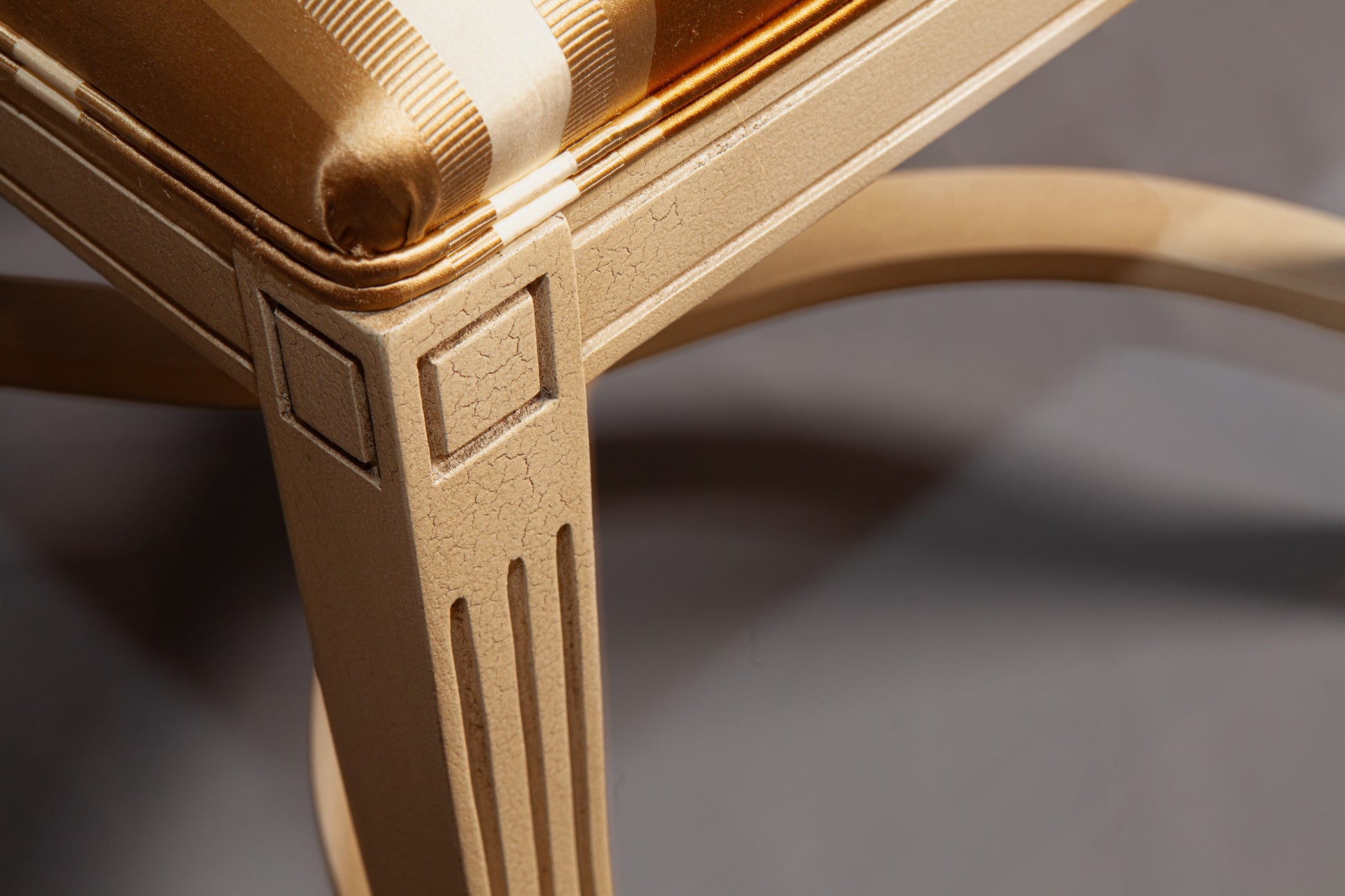 Angled perspective of a wooden chair emphasizing its carved legs and structure.