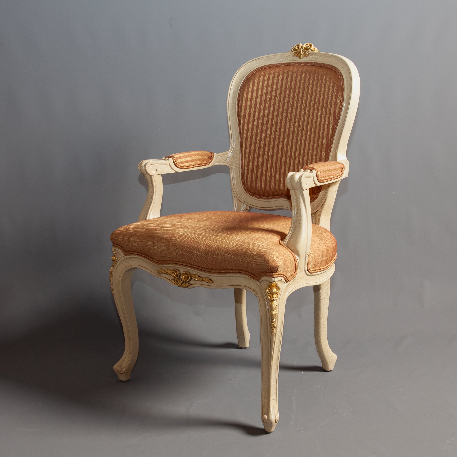 Louis XV armchair with ornate carvings and a cushioned seat in a rich fabric