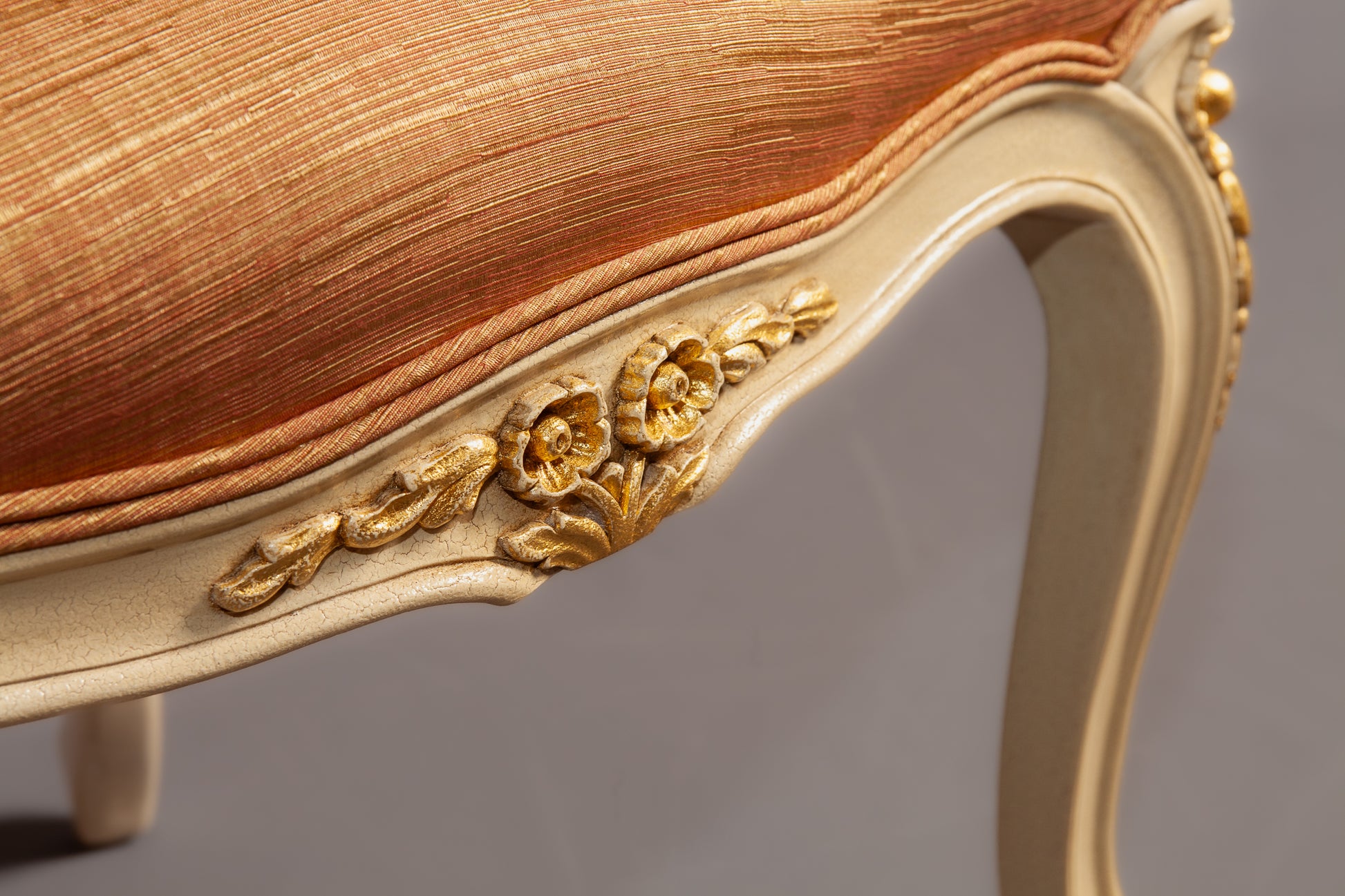 Detailed view of the armrest showcasing intricate carving and polished wood finish.