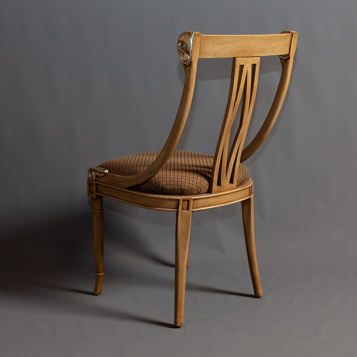 Elegant armchair with intricate carvings and upholstered seat.