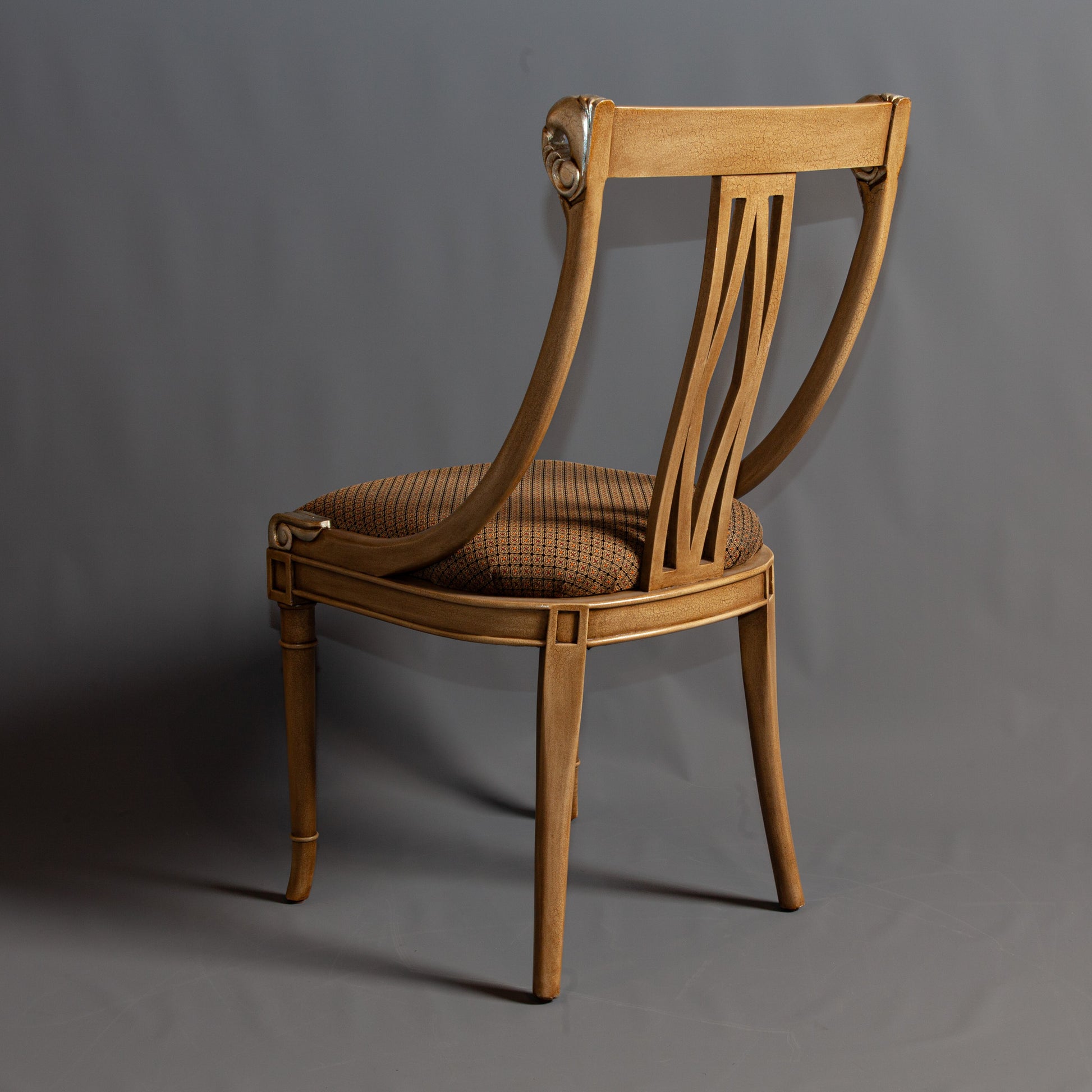 Elegant armchair with intricate carvings and upholstered seat.