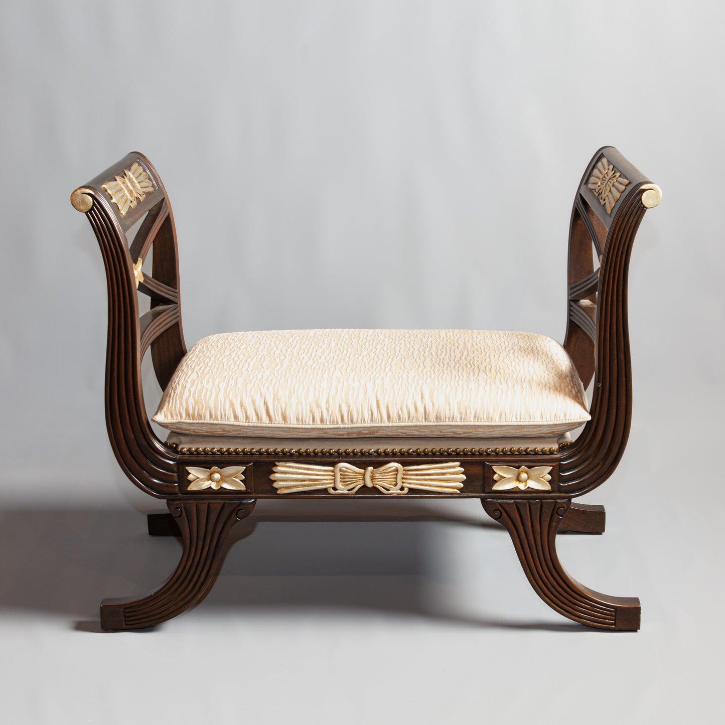 Empire-style wooden bench with gold accents.
