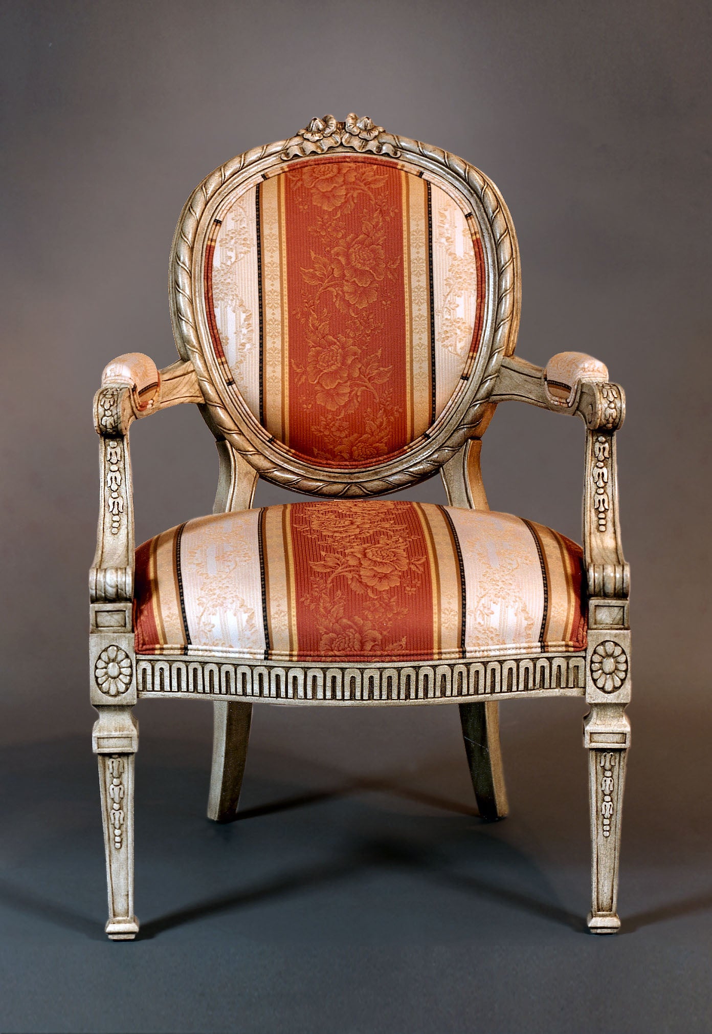 Side view of Louis XVI armchair highlighting detailed carvings and plush upholstery.
