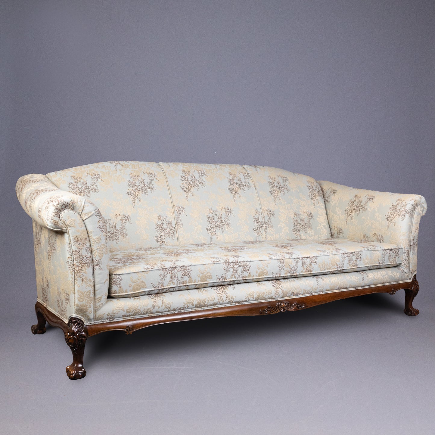 Large Georgian sofa with camelback design and rolled arms.