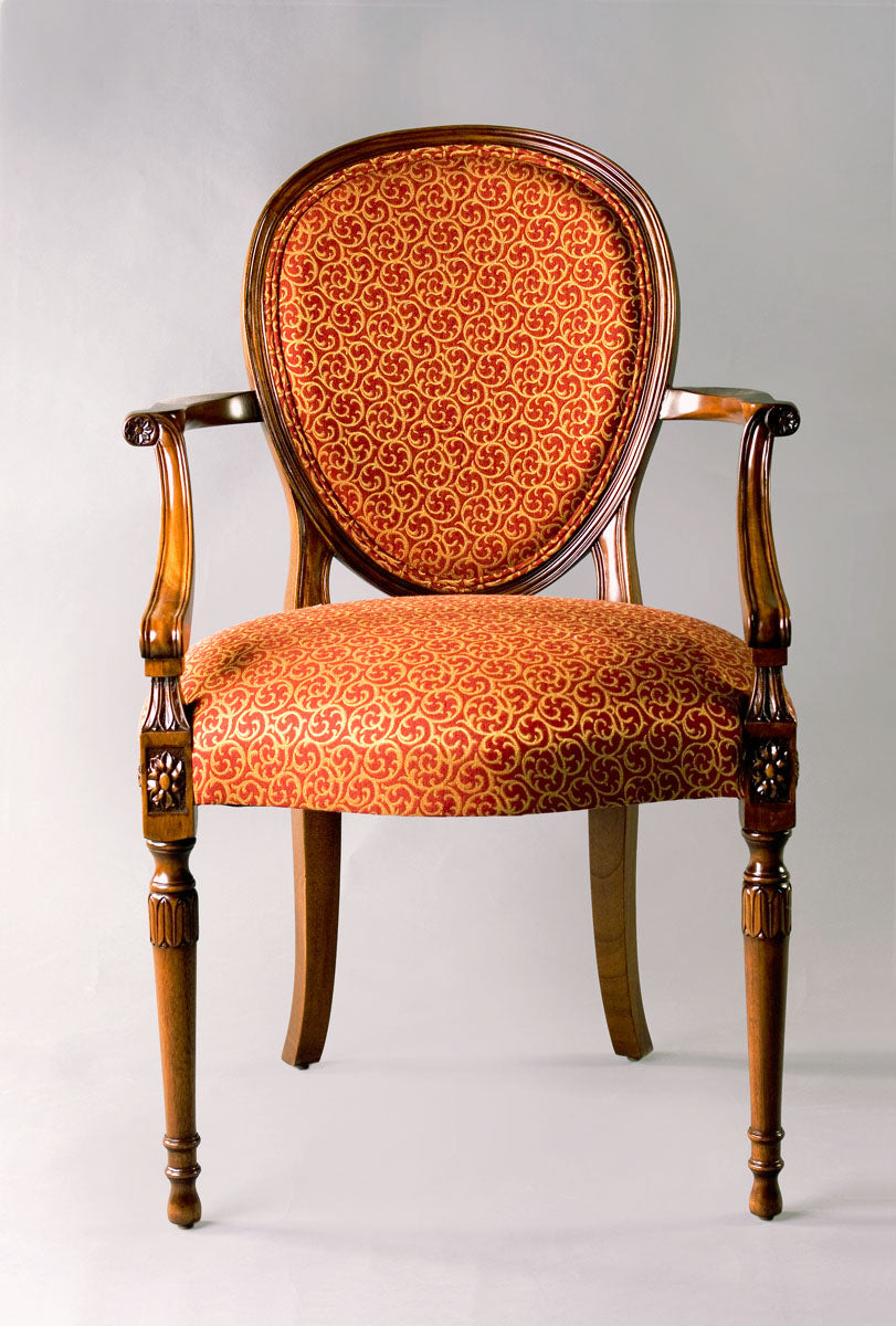 Carved wood chair with red patterned upholstery.