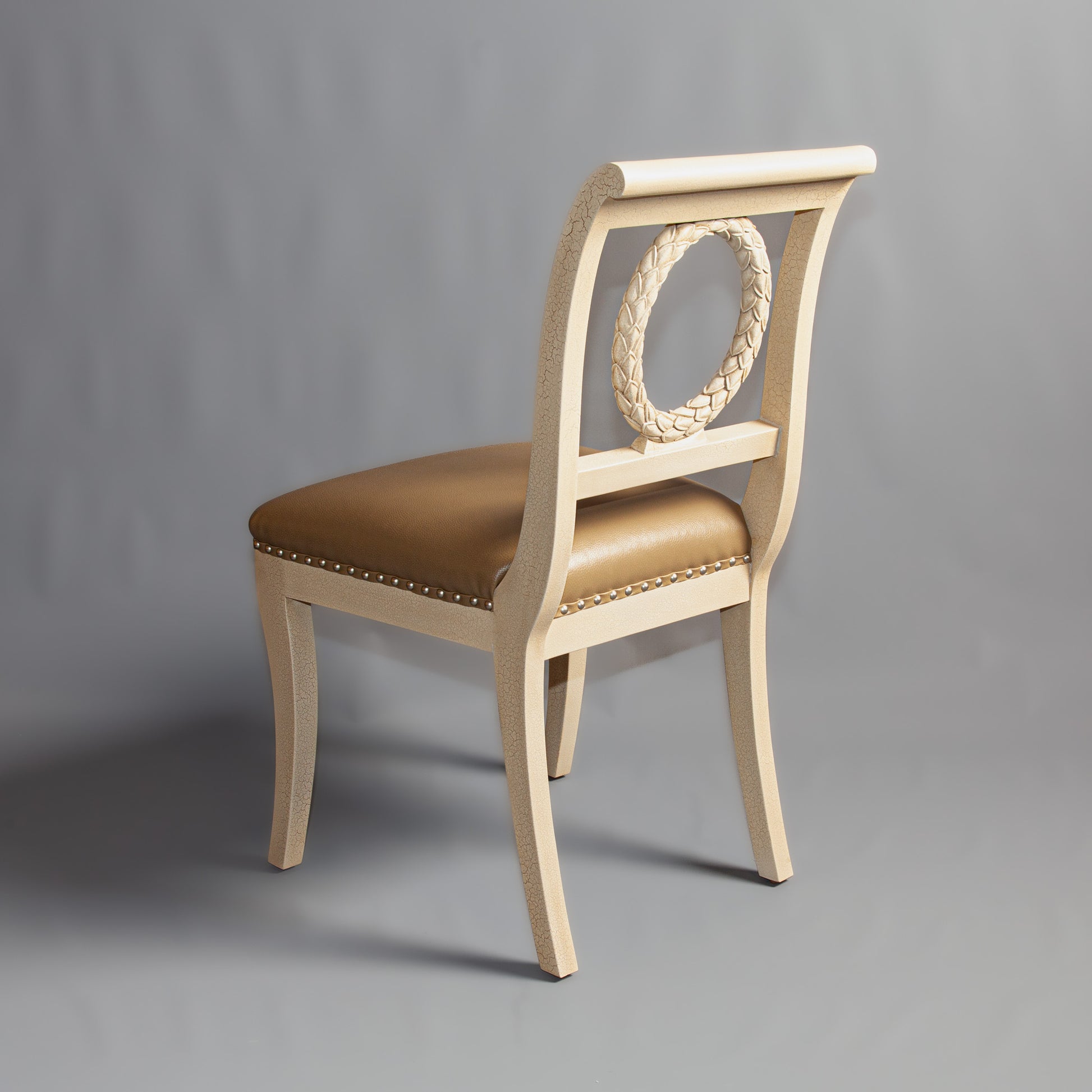 Front view of a sophisticated side chair with ornate wooden frame and cushioned seat.