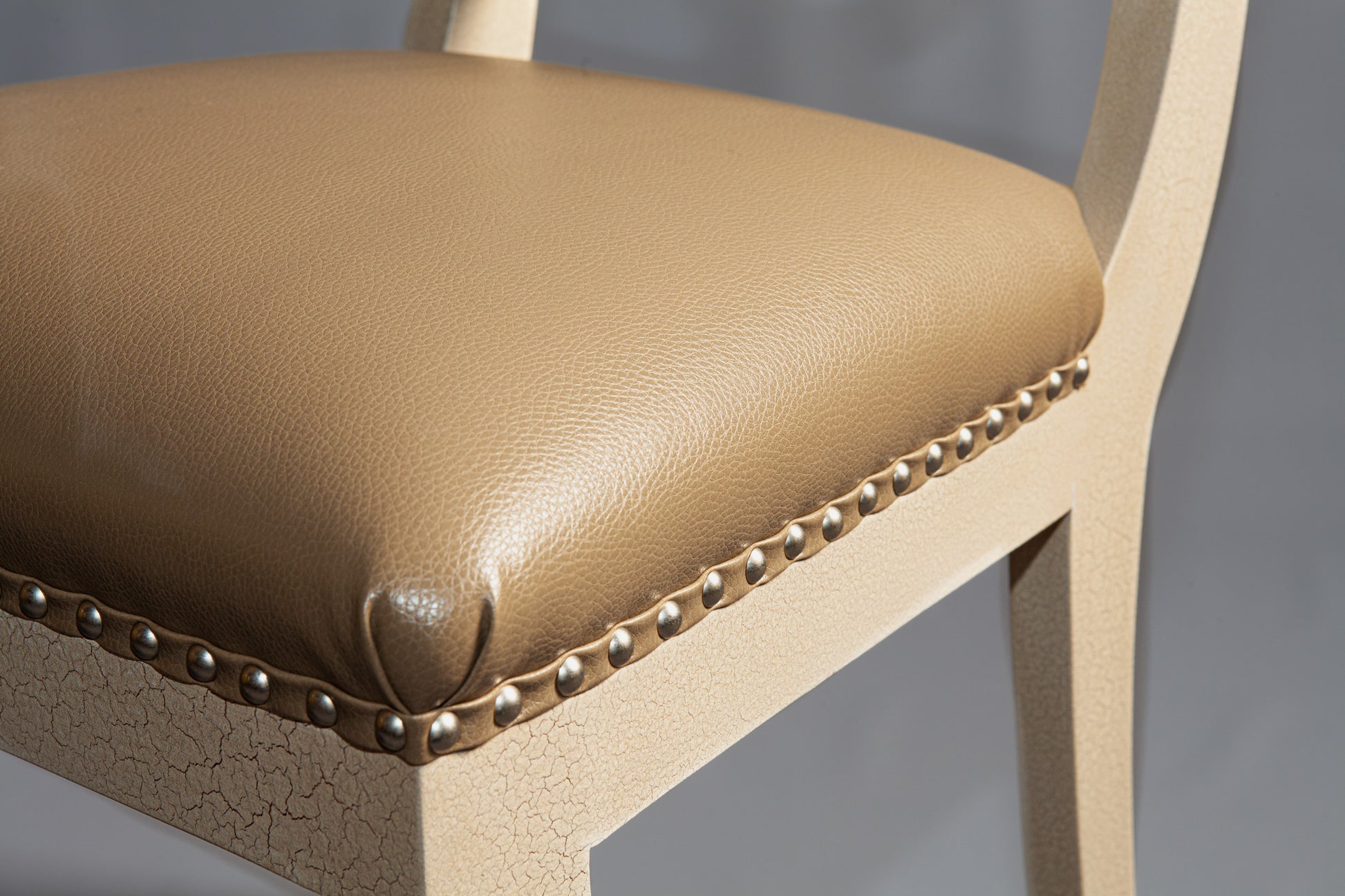 Side profile of a wooden side chair highlighting detailed carvings and fabric.