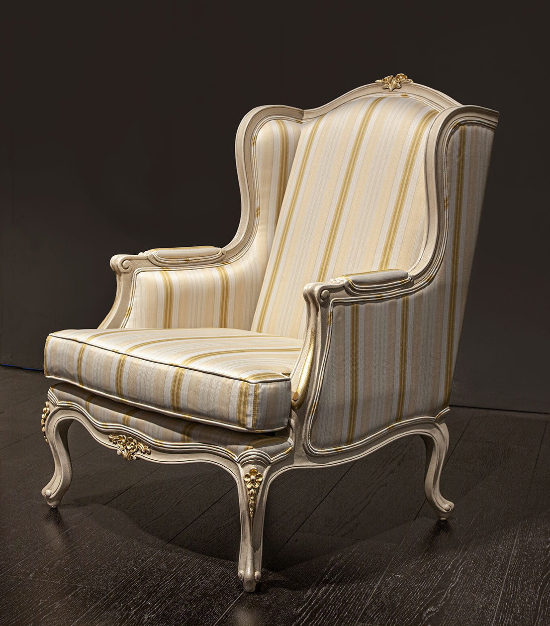 Louis XV wingback chair with plush upholstery and carved wooden legs.