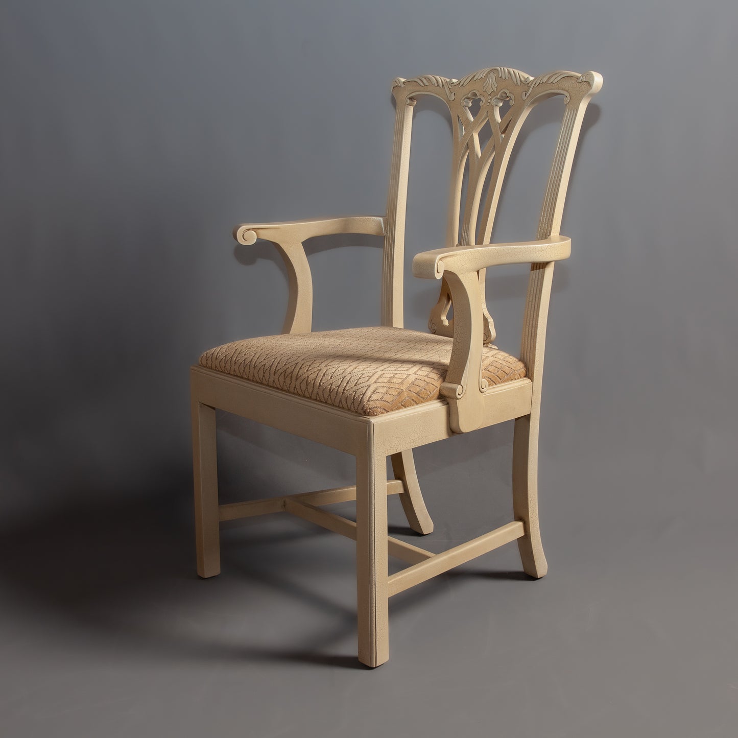 Elegant wooden chair with a carved backrest and upholstered seat.