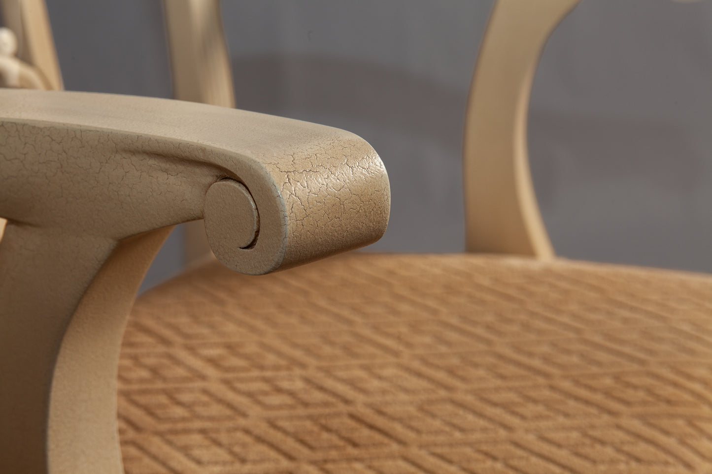 Close-up of the chair's backrest detailing ornate woodwork and fabric pattern.