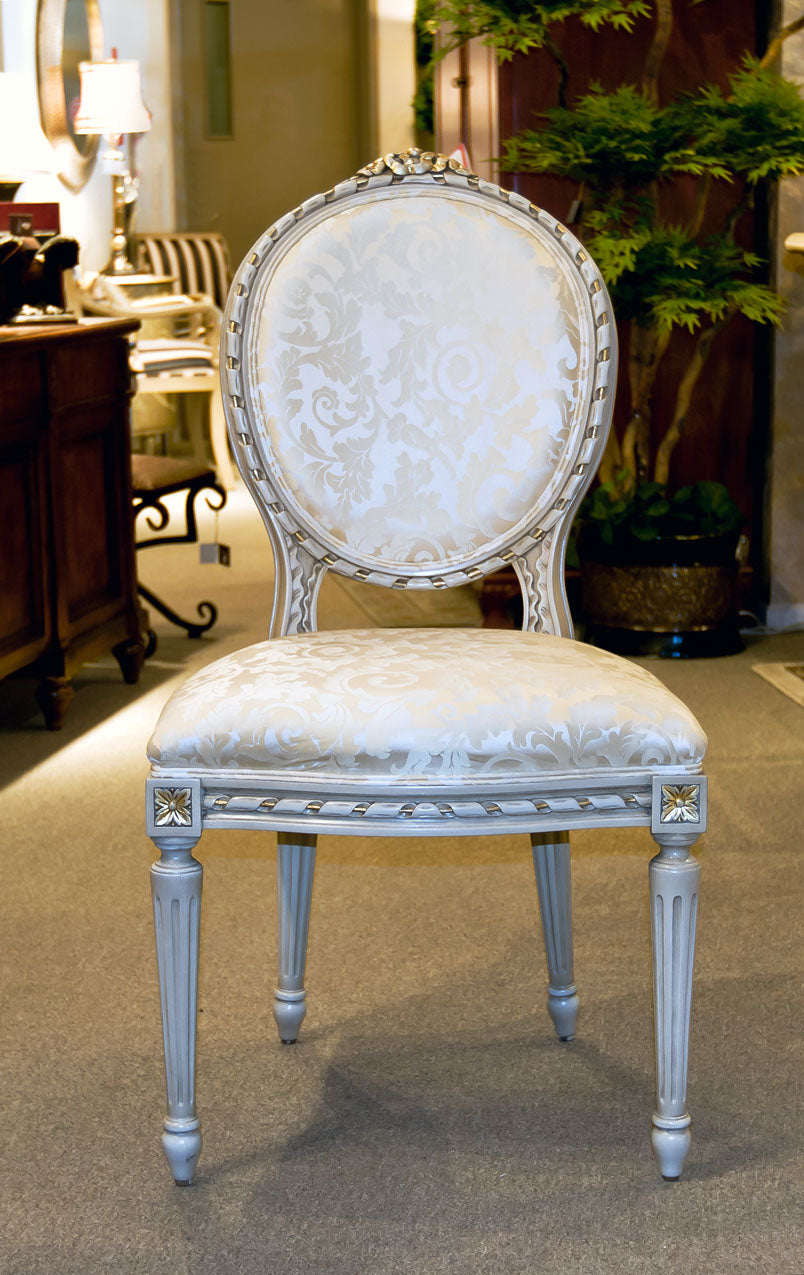 Louis XVI side chair featuring intricate carvings and cushioned seating