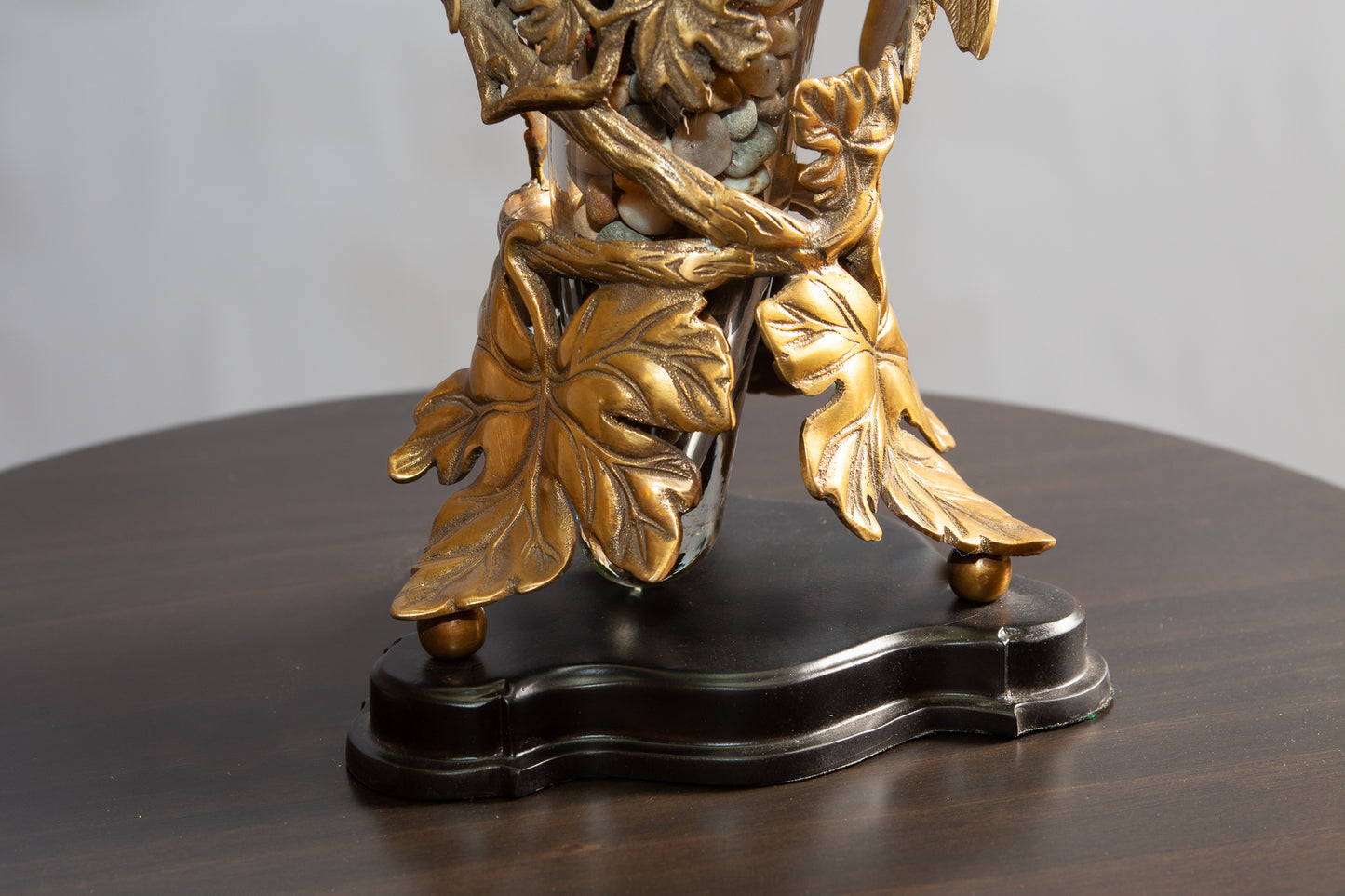 Detail view of metallic leaves and flowers vase on a table.