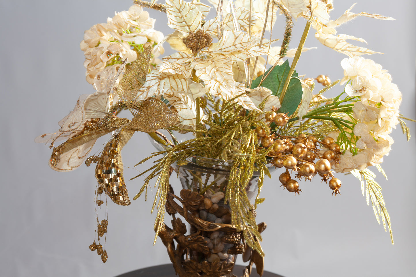 Close up view of decorative gold floral arrangement with intricate metallic leaves and flowers