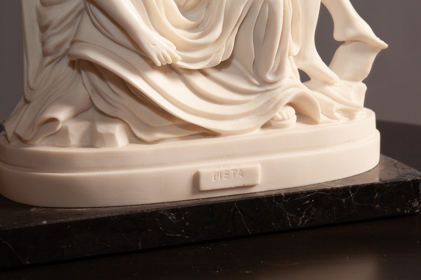 The base of white Pietà sculpture depicting Mary holding Jesus