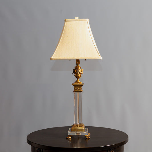 An ornate gold and beige lamp base with intricate carved detailing and curved handles.