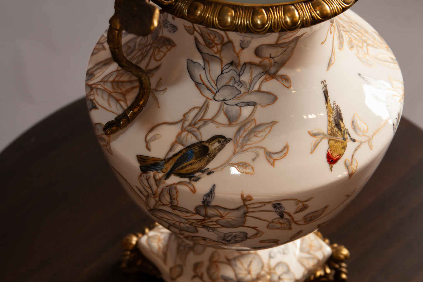 Close up view of painted birds on porcelain vase.