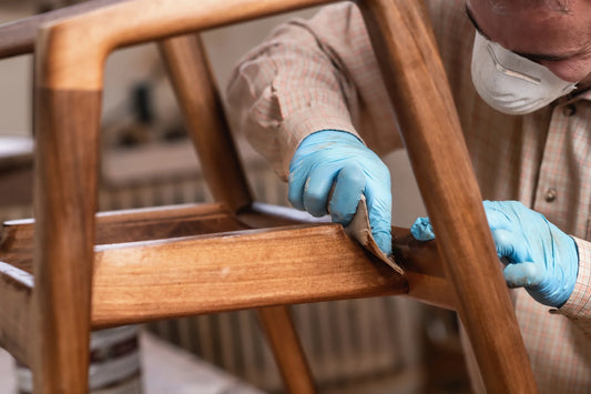 carpenter protecting wooden chair with polyurethane