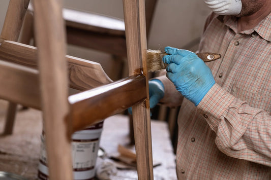 carpenter varnishing wood chair