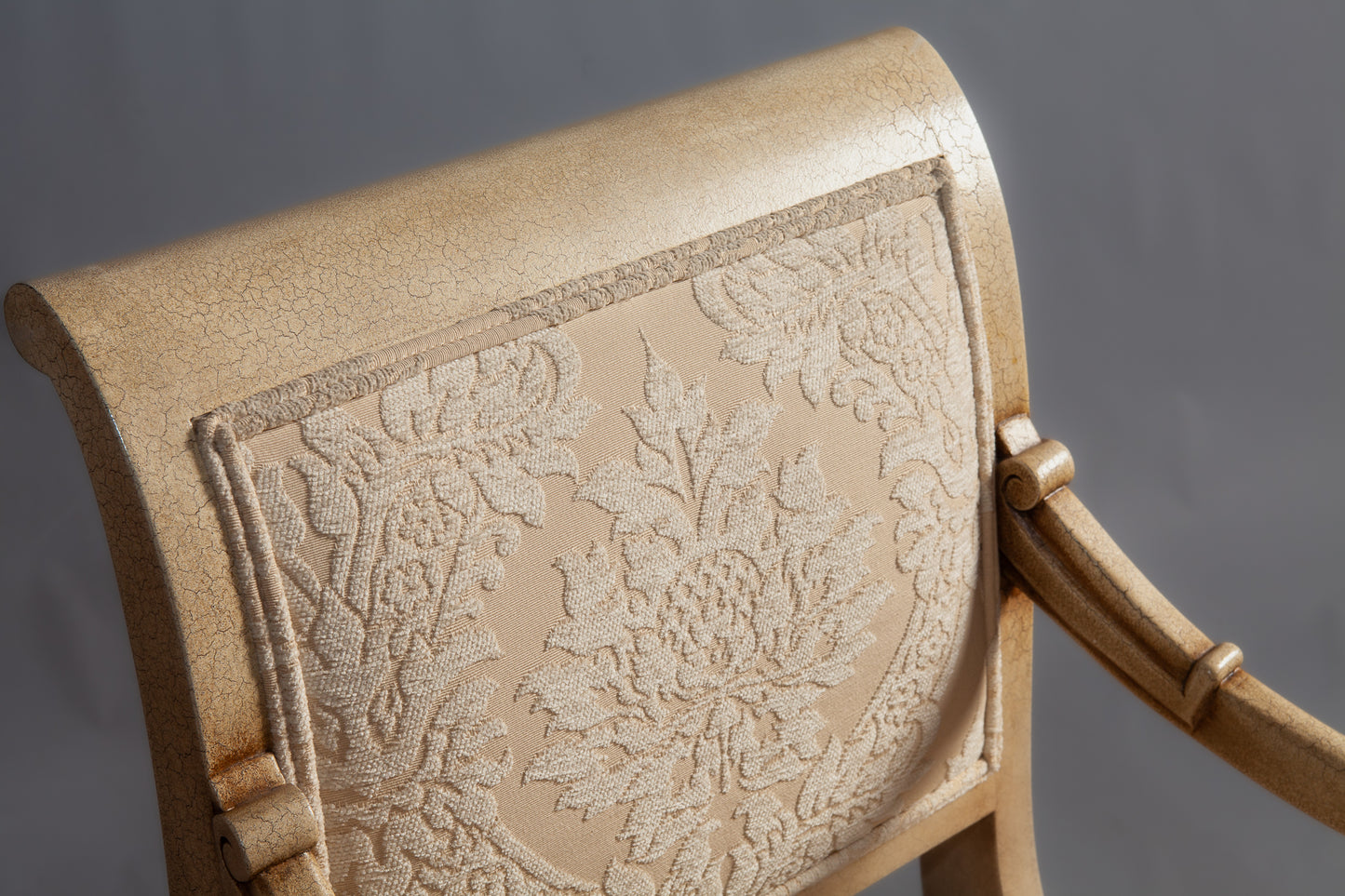 Close-up of the chair’s armrest featuring intricate carvings.