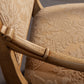 Front-facing view of a sophisticated armchair with ornate carvings and plush seating