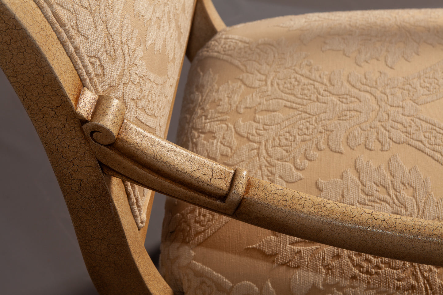 Front-facing view of a sophisticated armchair with ornate carvings and plush seating