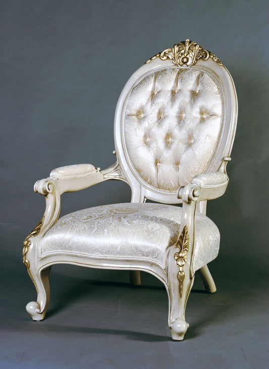 Victorian-style armchair with intricate carvings and tufted fabric upholstery.