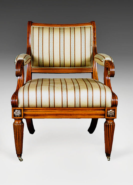 Regency-style armchair with rolled arms, carved details, and upholstered seat.