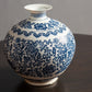 Close up view of wide blue and white ceramic vase with floral pattern