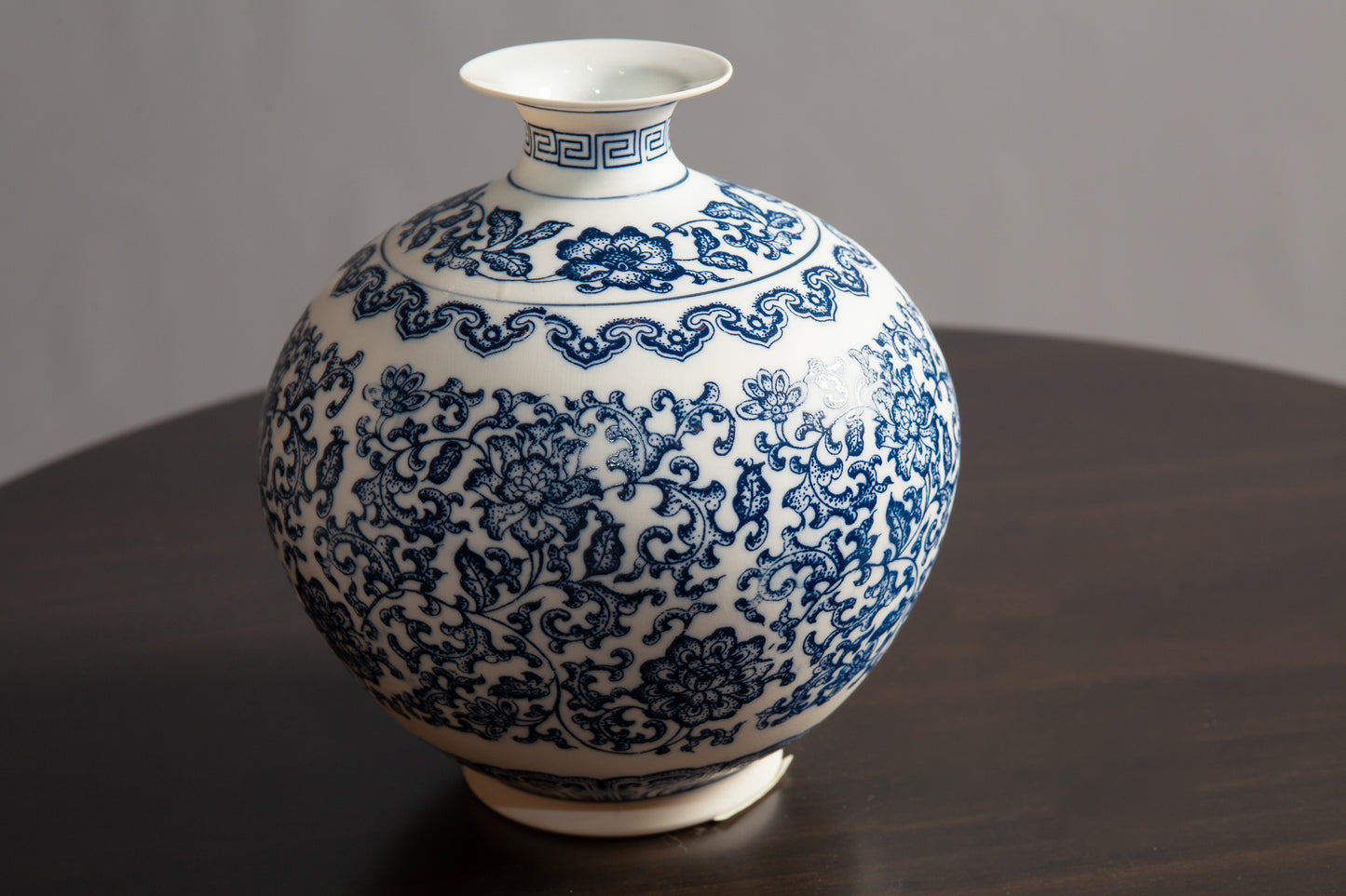 Close up view of wide blue and white ceramic vase with floral pattern