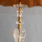 Lamp featuring a brass base and swirling crystal design for dynamic lighting.