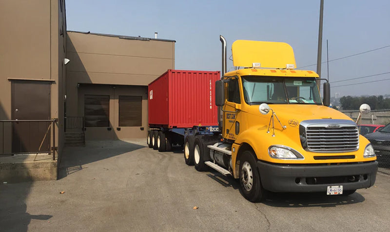 Yellow truck with red container for production delivery - House of Chippendale